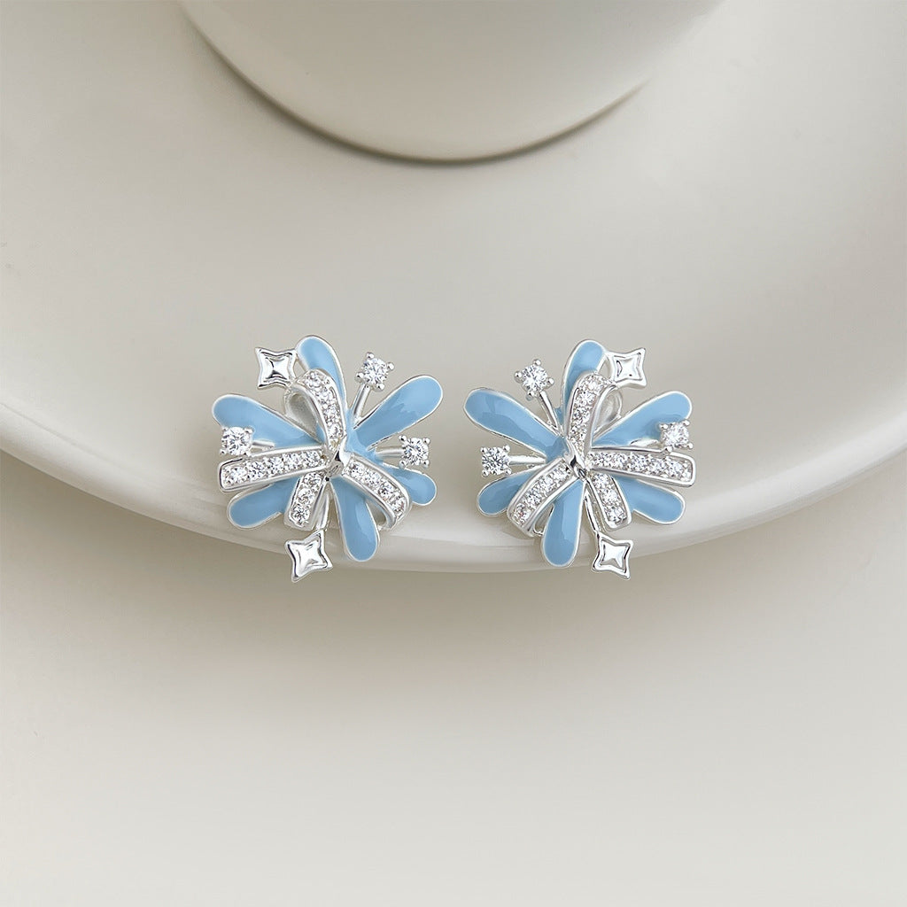 Light blue enamel firework stud earrings on white ceramic