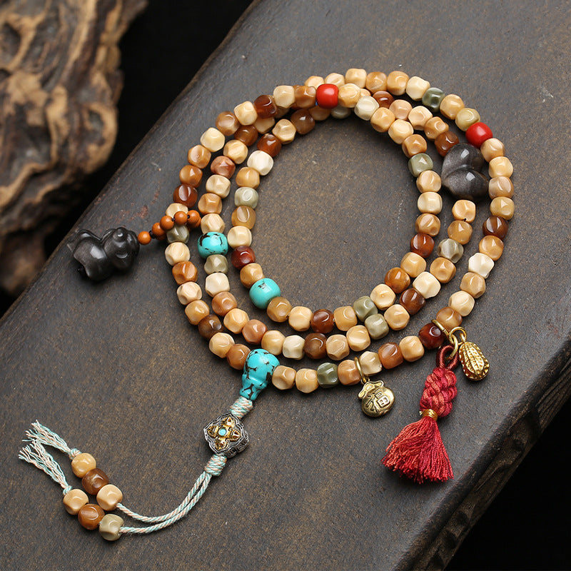 Jade patina dragon spine bodhi 108 mala coiled on dark wood surface showing full layout with all charms