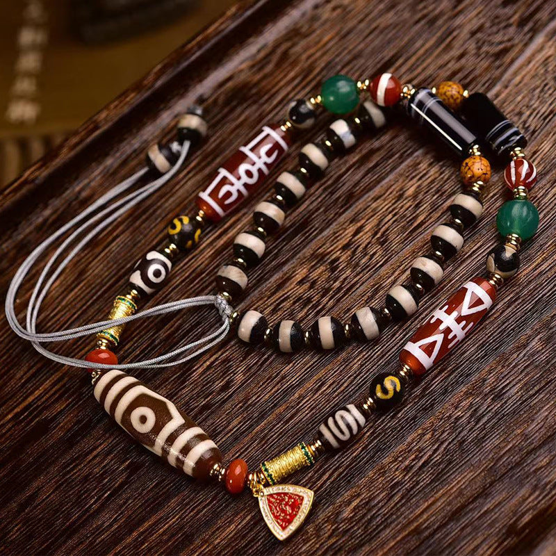 Dzi bead multi-stone necklace with enamel charm on wooden surface
