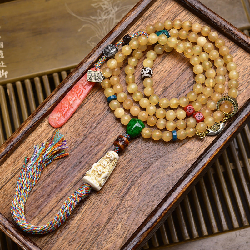 Tibetan antler 108 mala on wooden tray with bone carved netsuke, red agate and colorful tassel