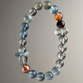 Brazilian mixed crystal bracelet with 9.5mm aquamarine, green phantom, red flower and clear quartz beads held in hand