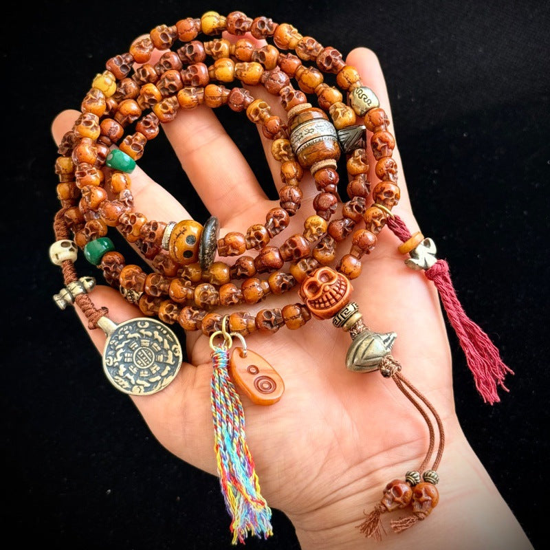 Tibetan yak bone Citipati skull mala held in hand showing full length