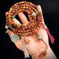 Tibetan yak bone Citipati skull mala held in hand showing full length