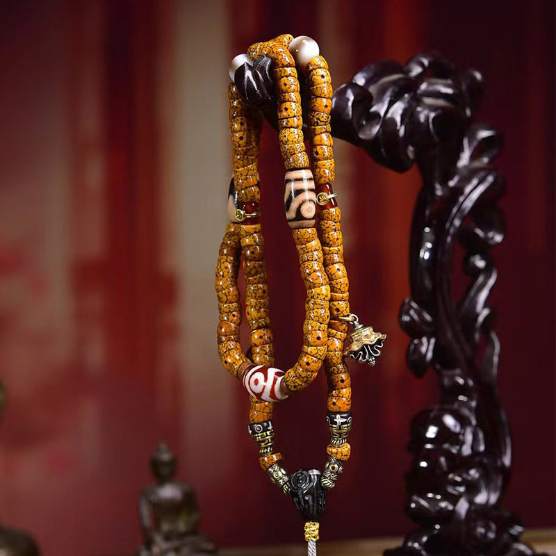 Crescent star bodhi mala held up on carved wooden stand showing full length and all pendants