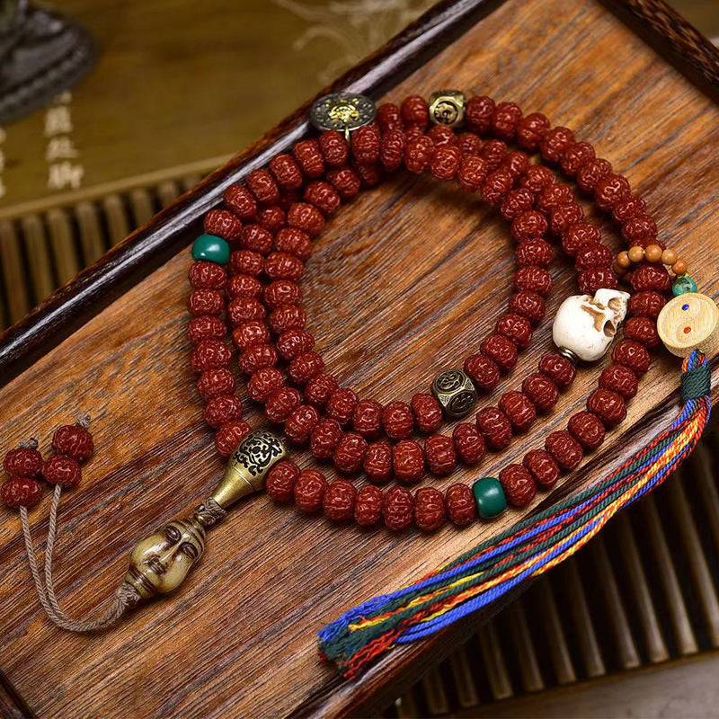 Rudraksha mala on wooden tray showing Buddha face guru bead and colorful tassel