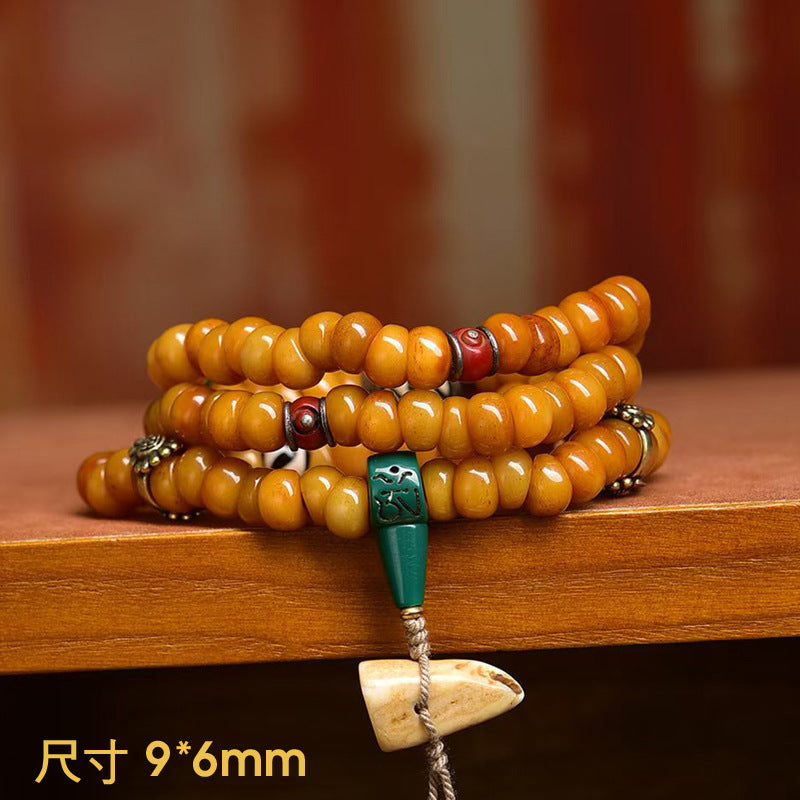 Yak bone disc mala draped over wooden edge showing 9x6mm bead size