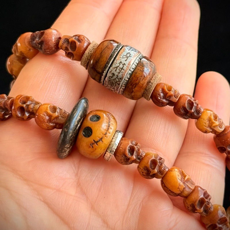 Close-up of camel bone guru bead and dzi stone spacers on skull mala