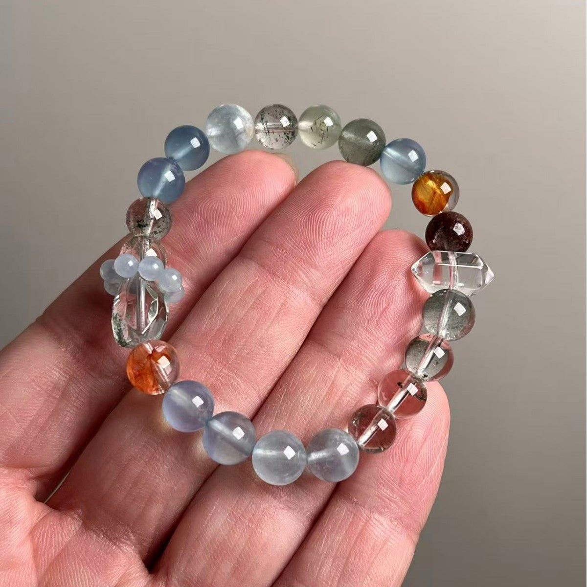 Natural mixed crystal bracelet showing color gradient and quartz inclusions