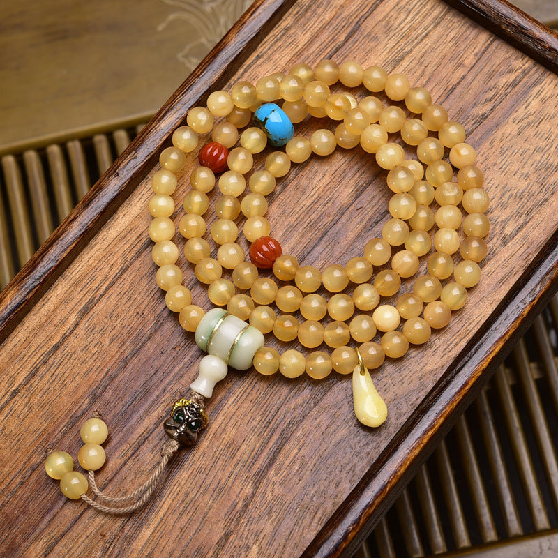 Antler mala on wooden tray with jade barrel guru bead, turquoise spacer and amber drop pendant