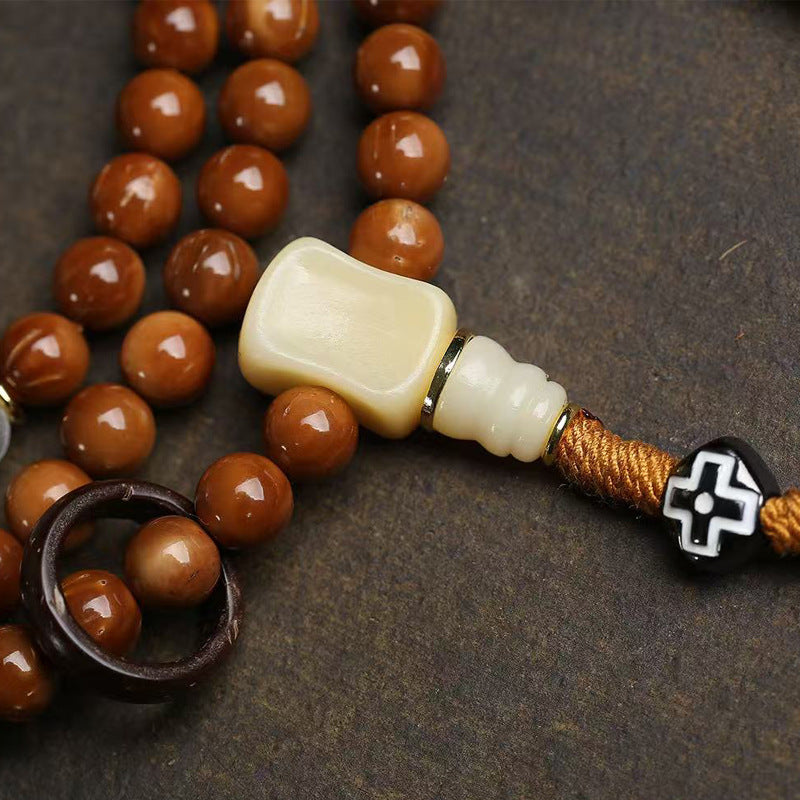 Detail of silver vajra pendant and dzi stone spacer on cook seed mala