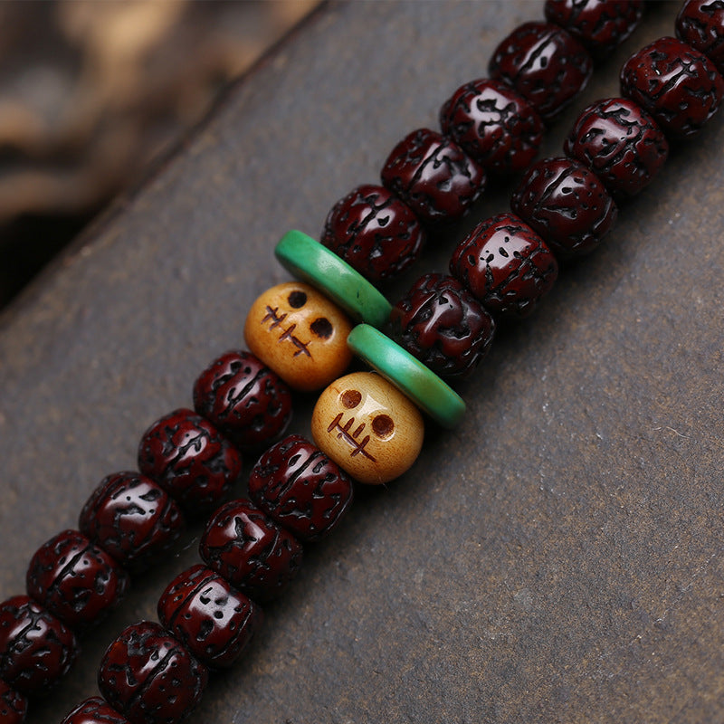 Close-up of bone skull spacer beads and turquoise disc spacers on rudraksha mala