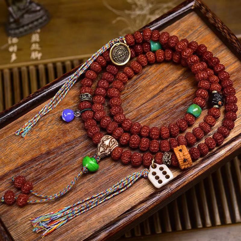 Rudraksha mala with turquoise spacers, bone dice charm and metal totem pendants