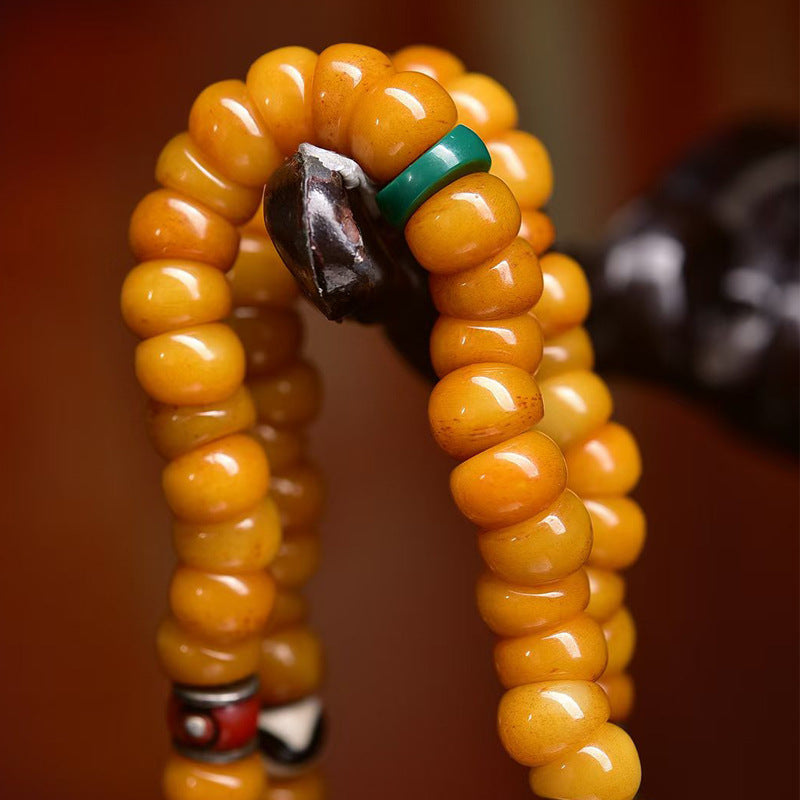 Close-up of dzi agate and old glass spacer beads on yak bone mala
