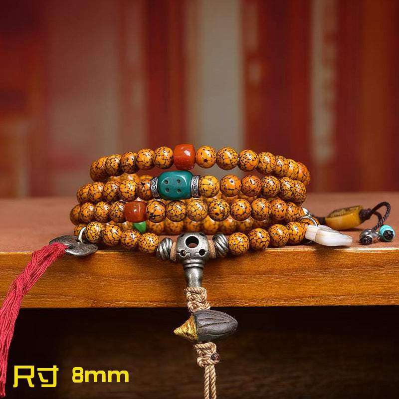 Cracked star moon bodhi mala wrapped as multi-loop bracelet on wooden surface showing 8mm bead size and turquoise spacer