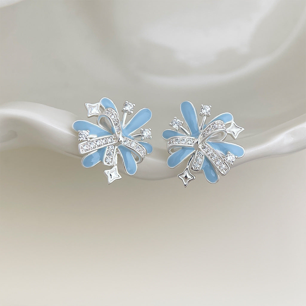 Pair of light blue firework earrings on satin