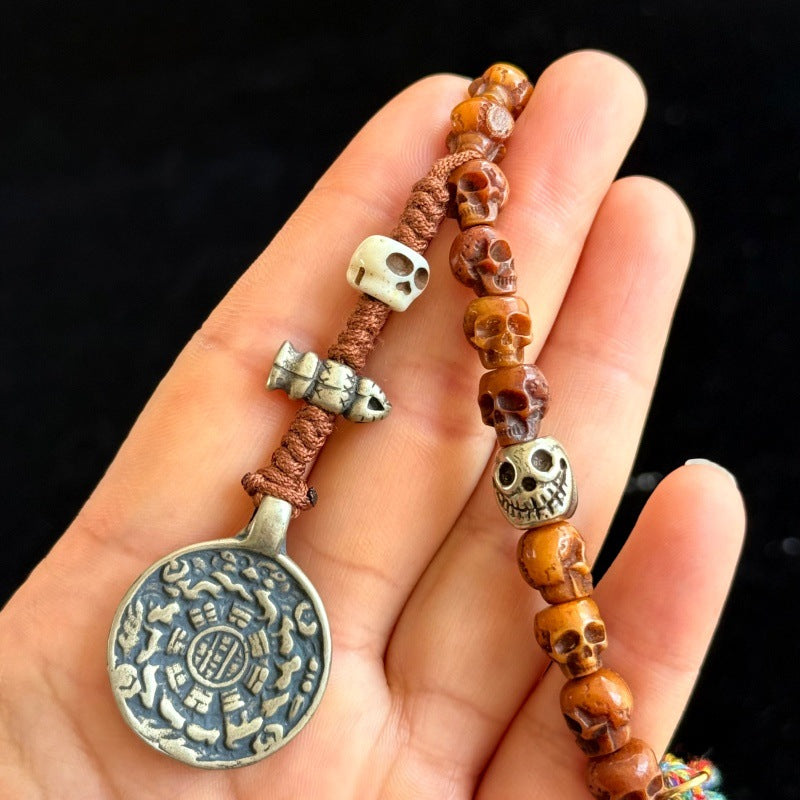 Detail of Tibetan silver Bagua zodiac pendant and skull counter beads