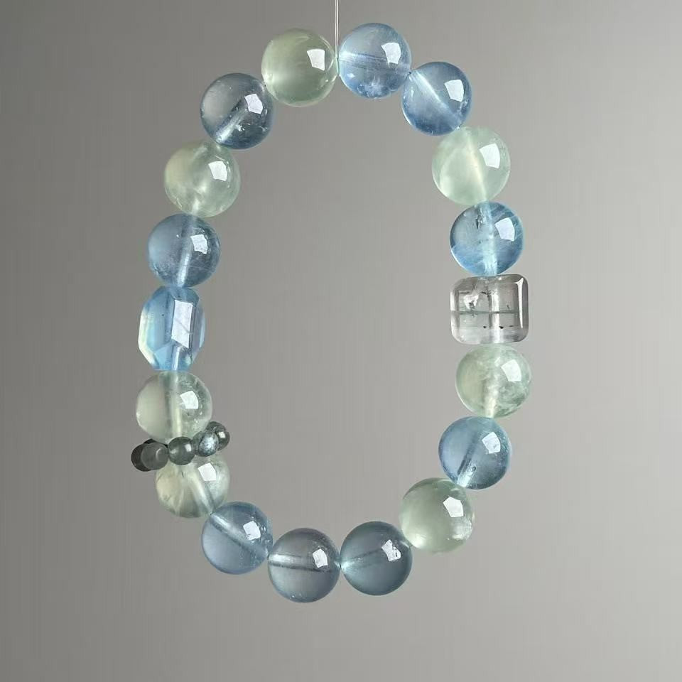 Close-up of aquamarine and clear quartz 11mm beads on neutral background