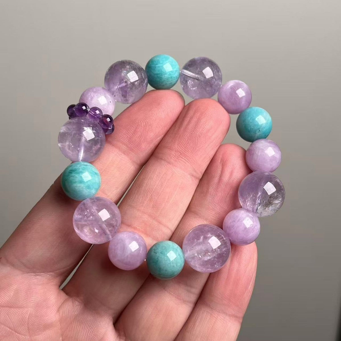 Amethyst mix crystal bracelet held in hand showing 12-14.5mm gradient beads