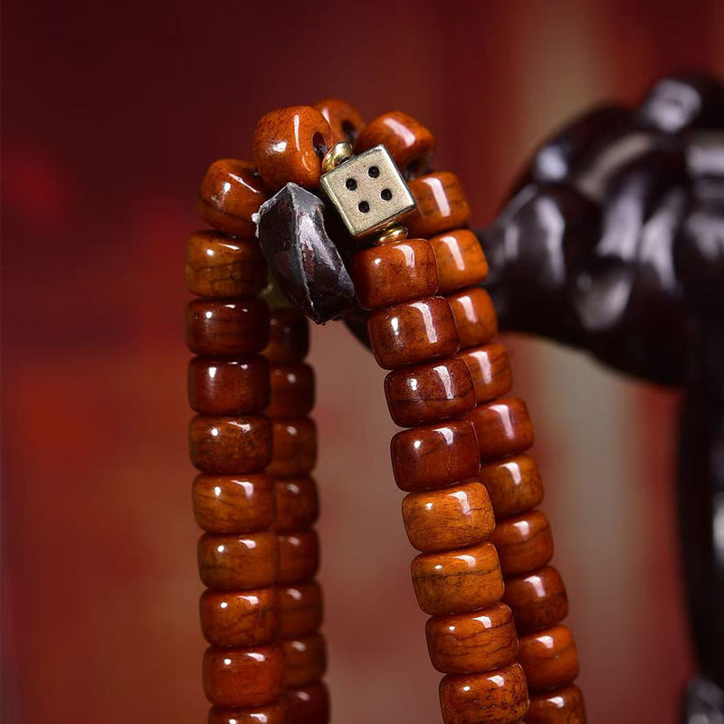Detail of yak bone barrel beads with metal dice bead and black stone charm