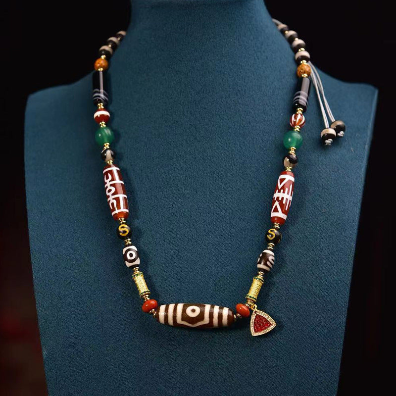 Dzi bead beaded necklace displayed on blue bust