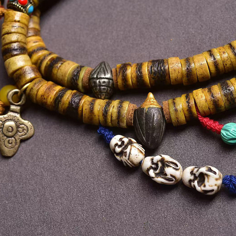 Close-up of yak bone mala beads with carved bone and turquoise details