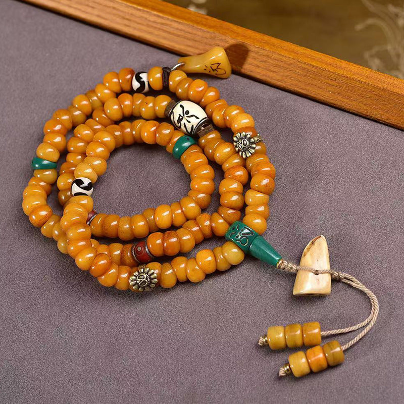 Full yak bone disc mala laid flat showing bone pendant and tassels