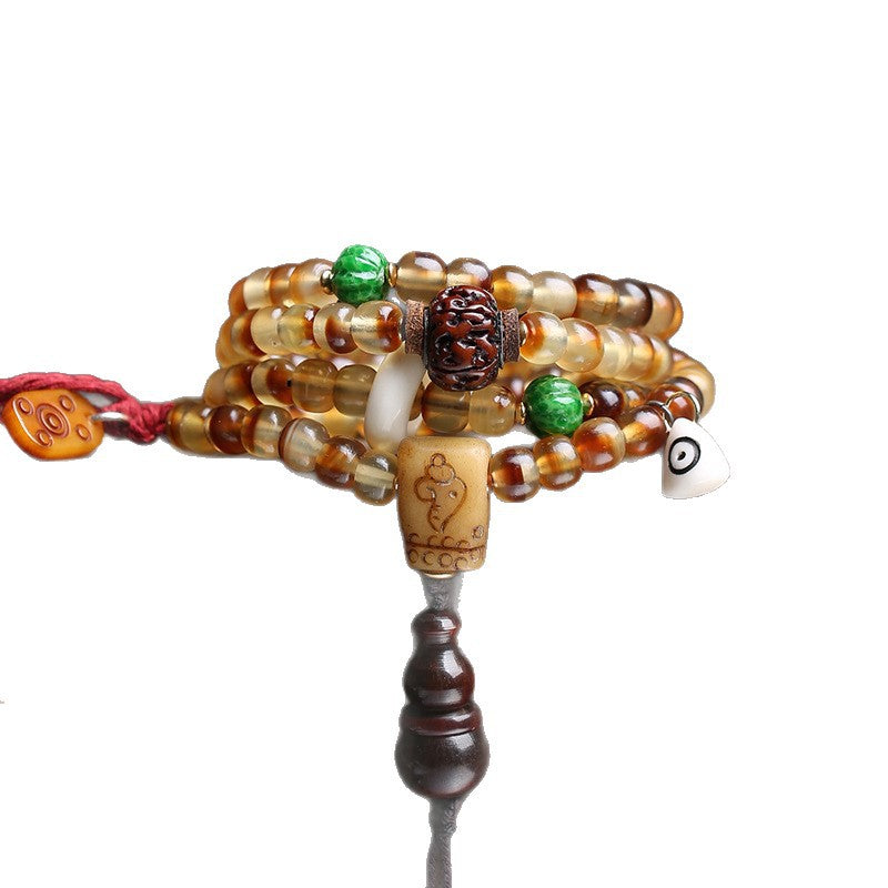 Turtle shell mala wrapped as multi-layer bracelet on white background showing all charms