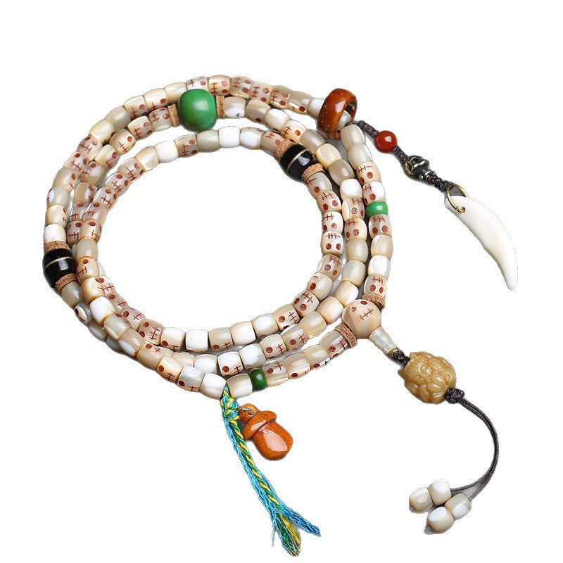 Full view of fish bone Ah-Dai 108 mala on white background showing all charms, agate spacers and colorful tassel