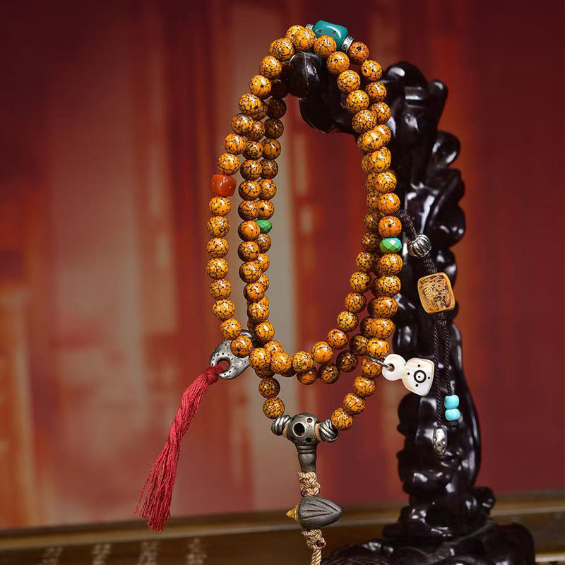 Cracked star moon bodhi mala draped on black carved figurine stand showing full drape and all charms