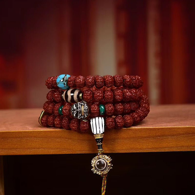 Rudraksha mala wrapped as multi-loop wrist bracelet showing turquoise and dzi stone charms