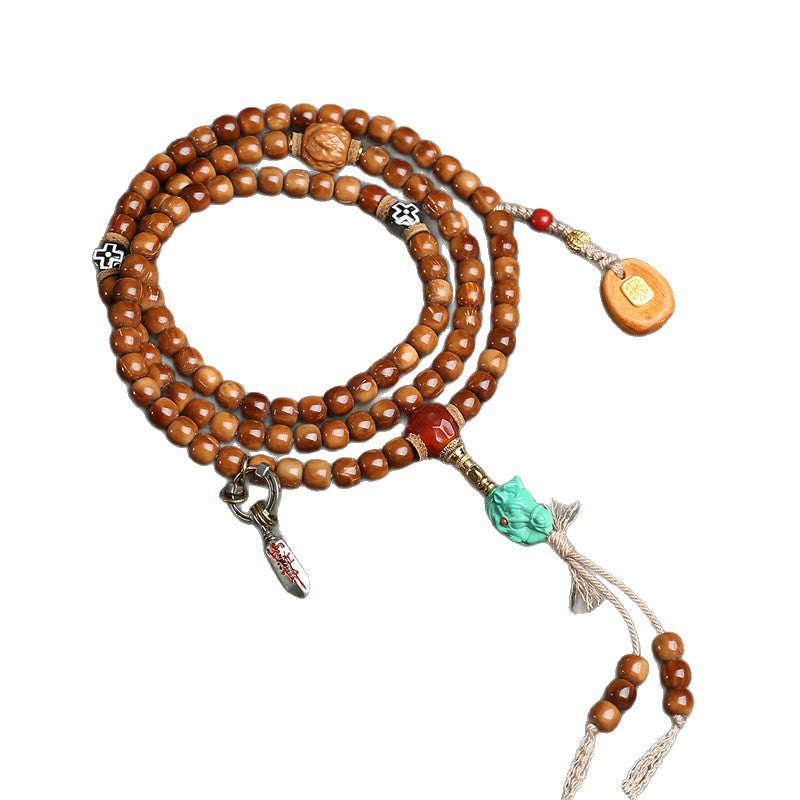 Full view of cocos 108 mala on white background showing all charms, tassels and pendants
